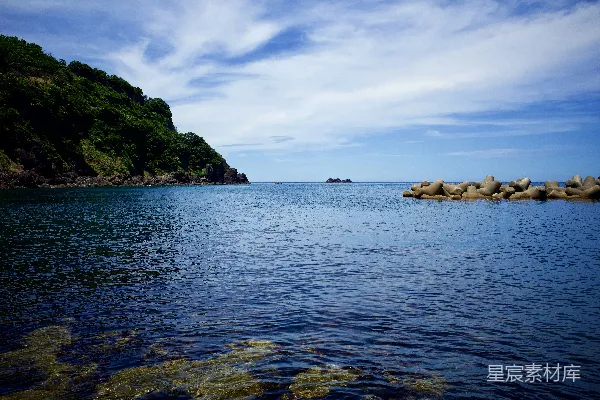 高清摄影 在白天，蓝蓝的大海下，白云飘浮在蓝天之间，形成了一道绿色和棕色的岩石景观。