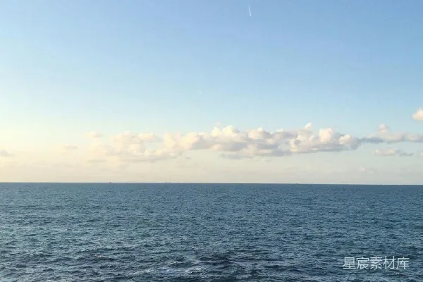 高清摄影 一个人坐在靠近海边的砖砌人行道边缘。
