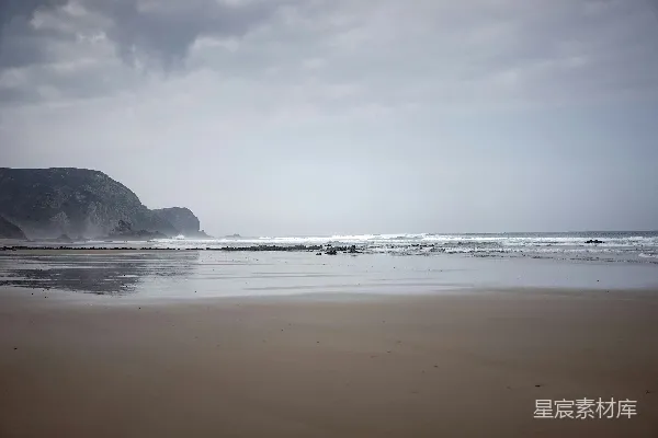 高清摄影 一个沙滩紧挨着一片水域。