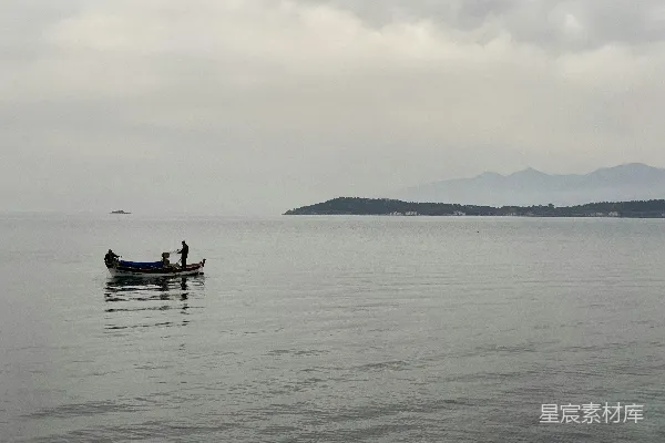 高清摄影 一艘小船上坐着几个人，漂浮在一片大水域上。