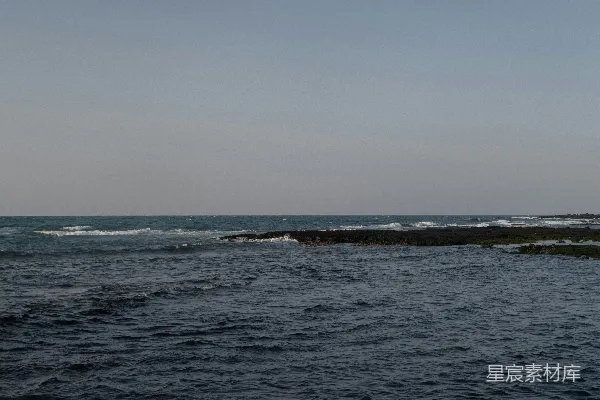 高清摄影 一片广阔的水域，海浪拍打着海岸。