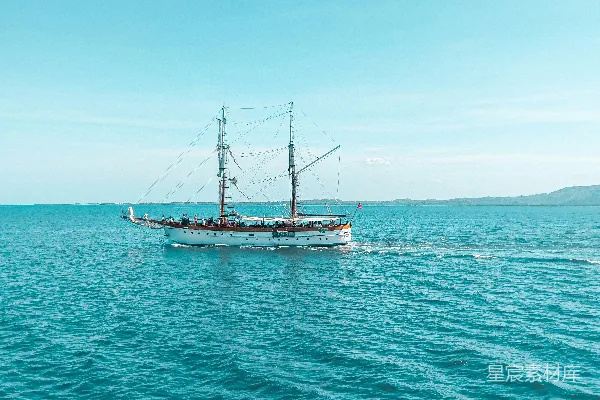 高清摄影 白天，蓝天下的海上，一艘棕白相间的船。