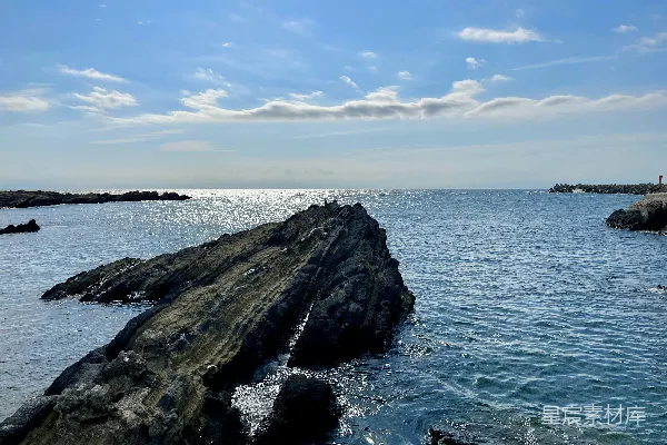 高清摄影 一个岩石海滩，背景中有一片水域。