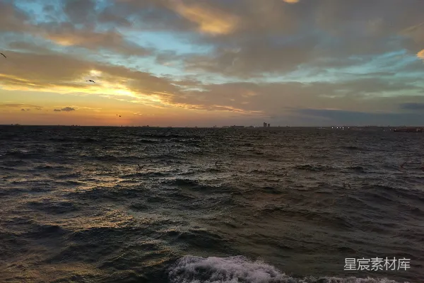 高清摄影 夕阳正缓缓落下，海面上有一艘船在远处航行。