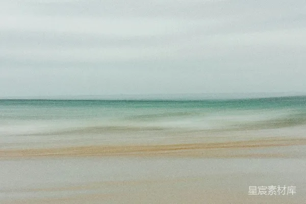 高清摄影 一张模糊的海滩照片，海浪拍打着岸边。