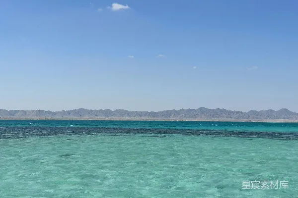 高清摄影 一片大水域，背景中有山脉。