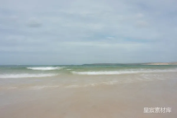 高清摄影 模糊的海滩照片，海浪正冲向岸边。