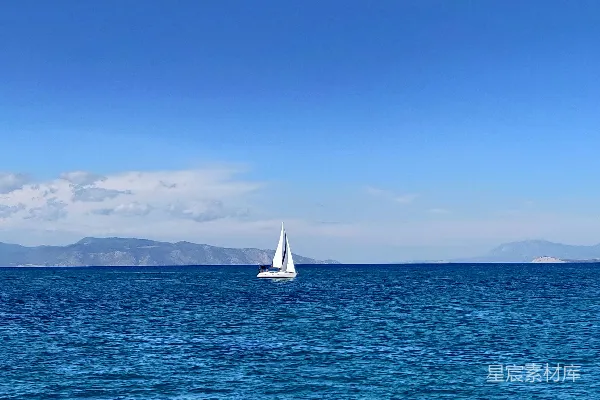 高清摄影 白天蓝天下的海面上有一艘白色帆船。