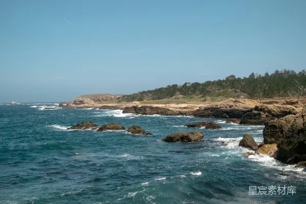 高清摄影 岩石海岸线在明媚的蓝天映衬下与海洋相接。