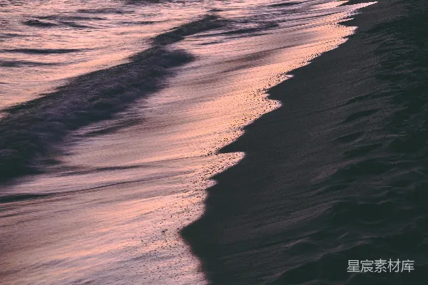 高清摄影 海浪拍打着海滩，夕阳西下。