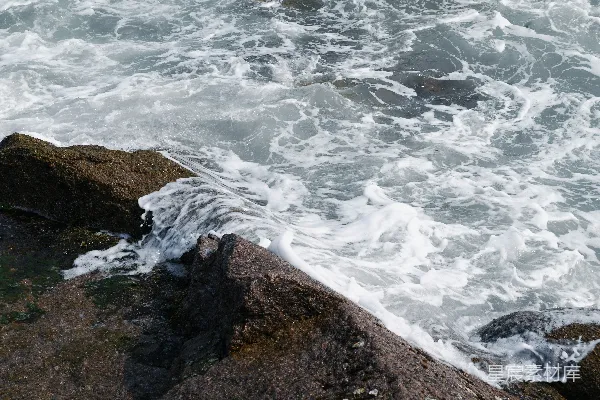 高清摄影 汹涌的海浪拍打着黑暗崎岖的岩石。