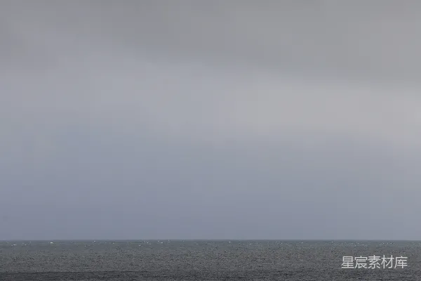 高清摄影 几个人在多云的天空下沿着海滩散步。