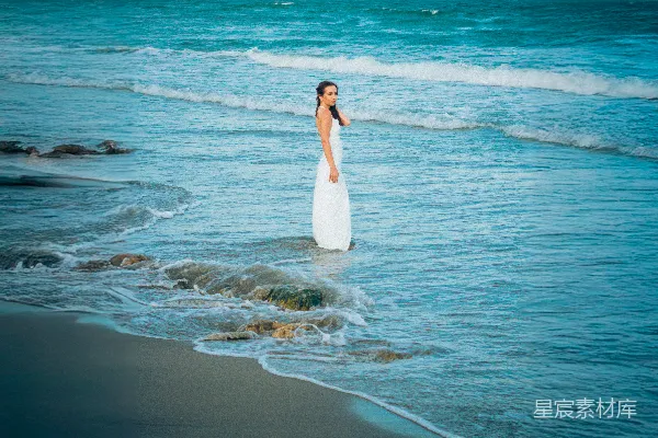 高清摄影 身穿白色连衣裙的女人站在海浪中