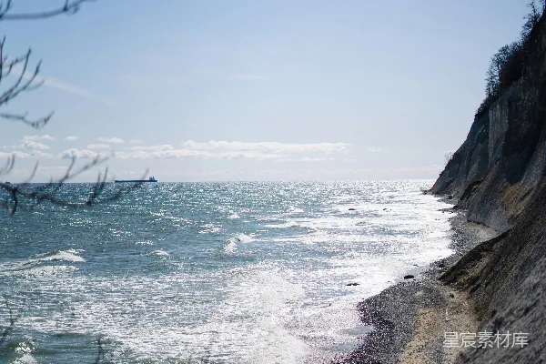 高清摄影 阳光明媚的日子，海浪拍打着悬崖边的沙滩。