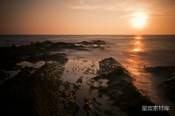 高清摄影 海边的黑色岩石在夕阳下显得格外醒目。