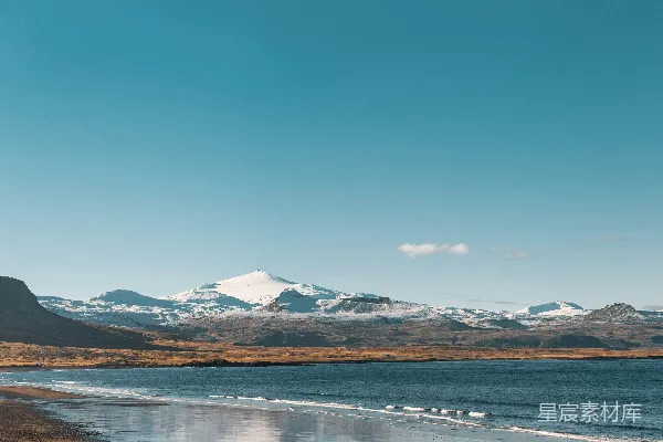 高清摄影 一片海滩的景色，背景是连绵的山脉。