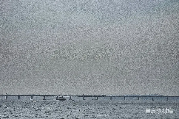 高清摄影 一大片水域，背景中有一座桥。