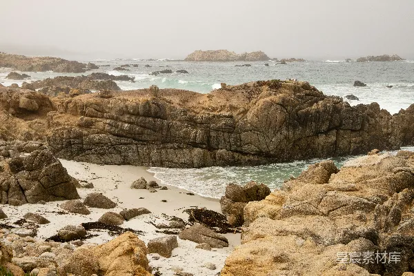 高清摄影 岩石海滩，背景中有一片水域。
