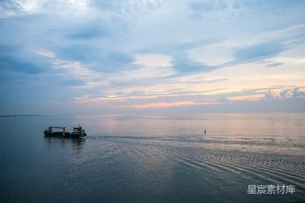 高清摄影 在夕阳下，货轮在平静的水面上航行。