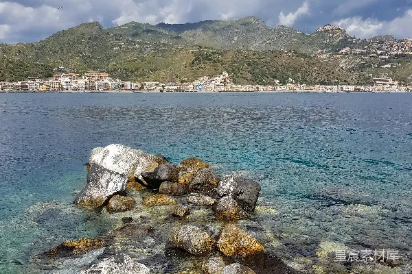 高清摄影 一个岩石海滩，远处有一座小镇。