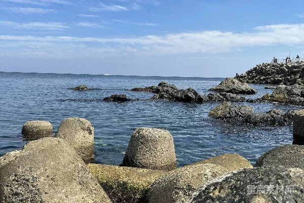 高清摄影 一个岩石海滩，背景中有一片水域。