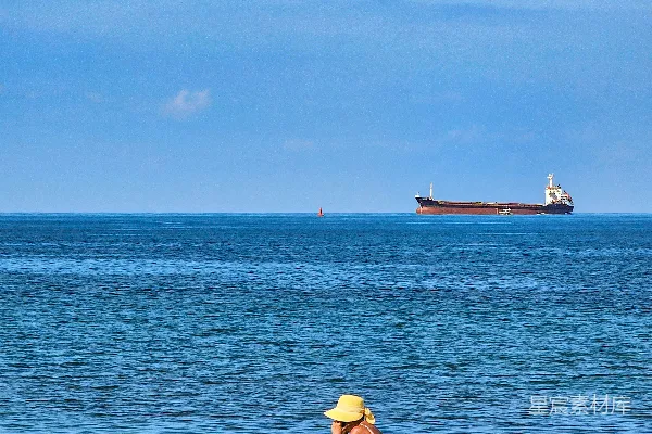 高清摄影 一个女人坐在海滩上，靠近大海。