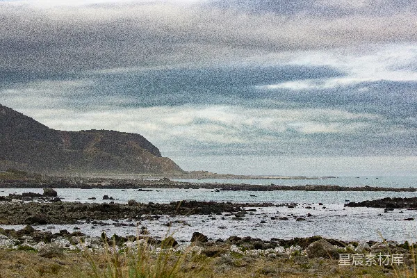 高清摄影 崎岖的海岸线，山脉环绕，岩石海岸，天空多云。
