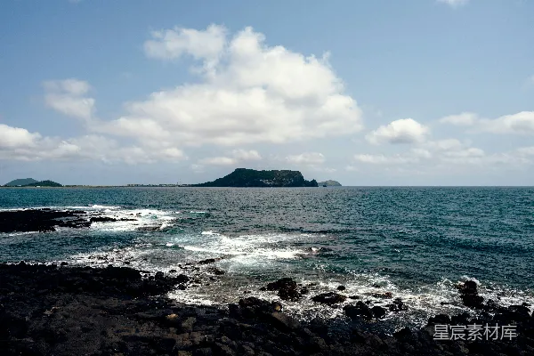 高清摄影 一个岩石海滩，背景中有一大片水域。
