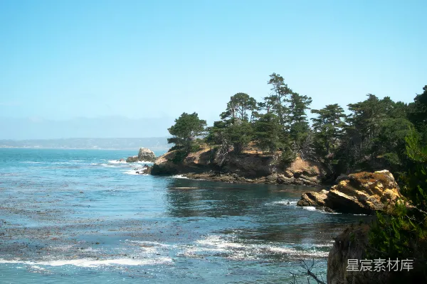 高清摄影 海洋与蓝色天空相接，岩石海岸线矗立其中。
