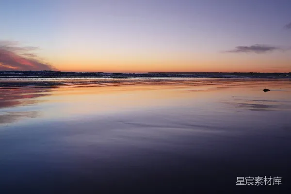 高清摄影 夕阳正映在水面上的海滩上。