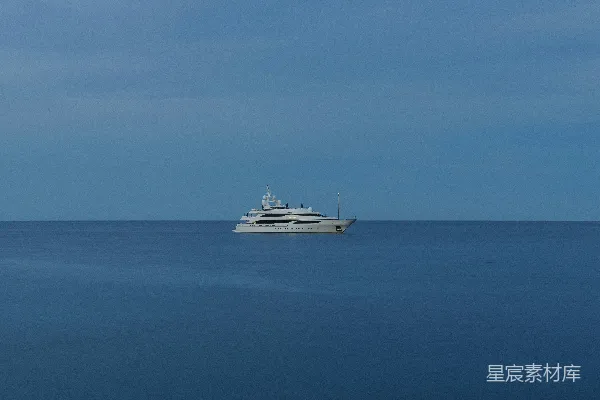 高清摄影 一艘游艇漂浮在海洋平静的蓝色水面上。