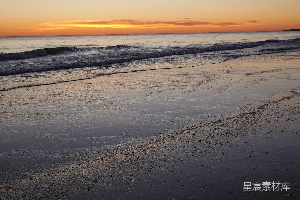 高清摄影 夕阳正照在海滩的水面上。