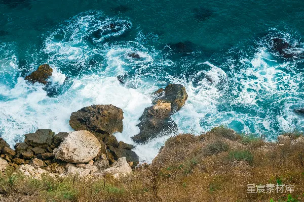 高清摄影 白天，棕色岩石海岸旁有蓝色的海浪。