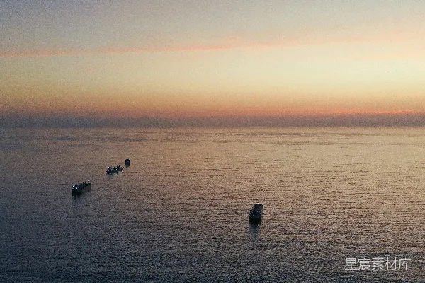 高清摄影 夕阳下的海洋上有几艘船。