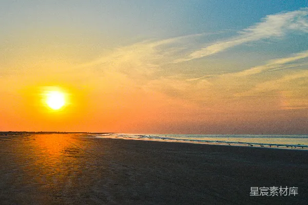 高清摄影 夕阳西下，海滩上，大海在背景中。