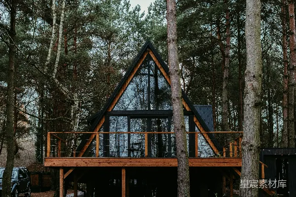 高清摄影 一间林中的小屋，周围环绕着树木。