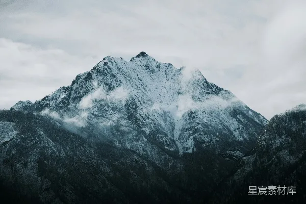 高清摄影 覆盖着积雪的山峰在阴云密布的天空下