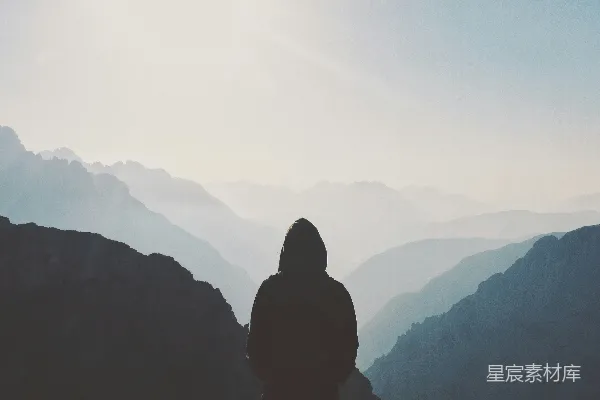 高清摄影 穿连帽衫的男人站在山前
