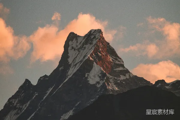 高清摄影 一座被雪覆盖的山峰，背景中有云雾。