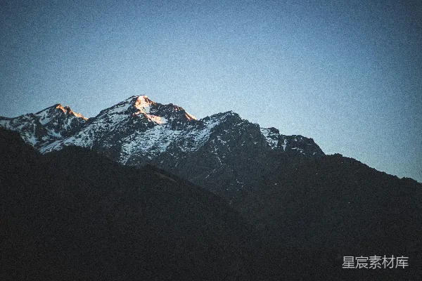 高清摄影 一座被雪覆盖的山峰，背景是蓝天。