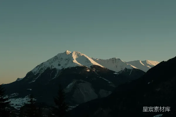 高清摄影 一座被雪覆盖的山，山上有树木。