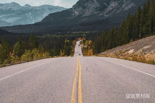 高清摄影 一条空旷的道路，背景中有山脉。
