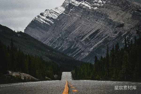 高清摄影 一条空旷的路，背景是一座山。