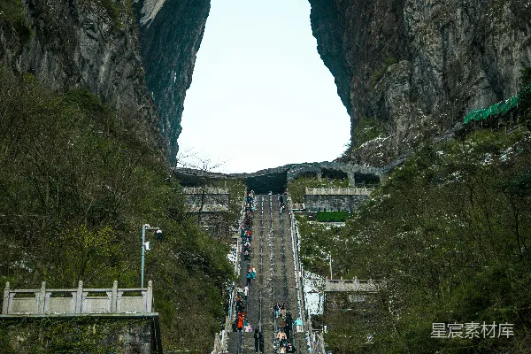 高清摄影 人们沿着长长的楼梯走向一座岩石拱门。