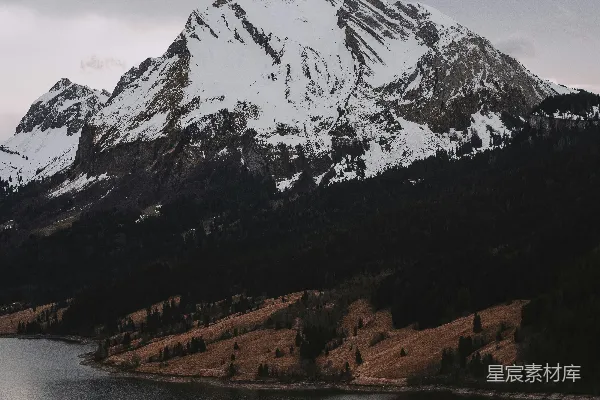 高清摄影 一座覆盖着雪的山，前景中有一片湖泊。
