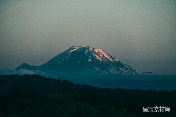 高清摄影 一座雪山，山脚下有树木。