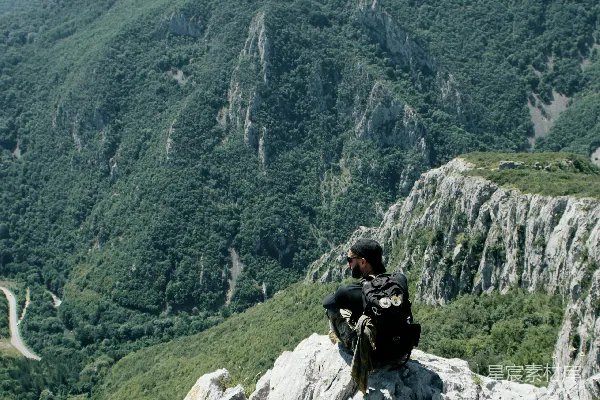 高清摄影 穿黑色夹克的男人坐在白天的岩石山丘上。
