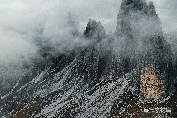 高清摄影 在阴云密布的一天，山上覆盖着积雪和云雾。