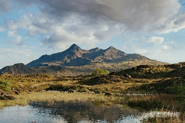 高清摄影 一座小湖被群山环绕，天空布满云层。