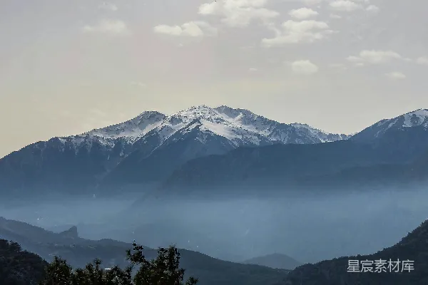 高清摄影 白天多云的天空下覆盖着雪的山峰